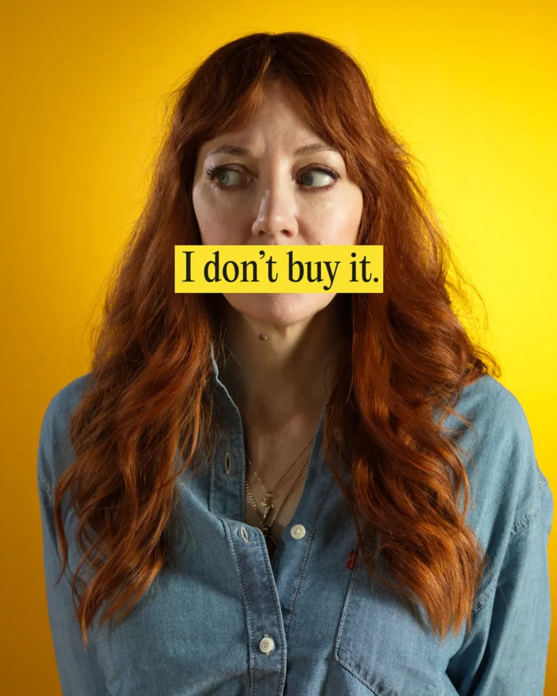 Comedian Diane Morgan, against a warm yellow backdrop, looking to her right, with text overlay saying "I don't buy it"