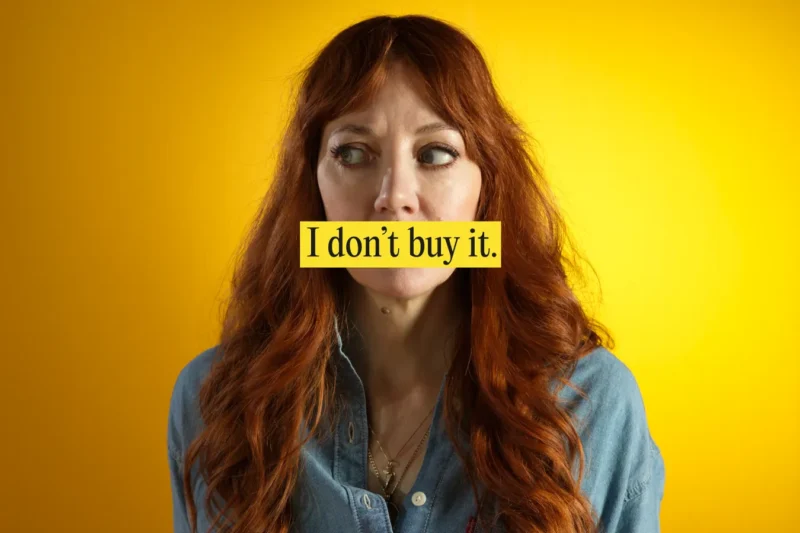 Diane Morgan against a warm yellow backdrop with text overlay saying "I don't buy it"