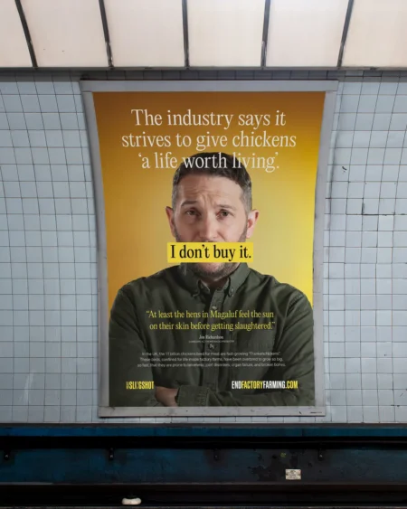 A campaign poster for End Factory Farming displayed in a London Underground station, featuring comedian Jon Richardson and the text "I don't buy it."