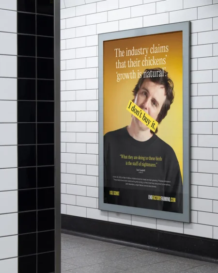 A campaign poster for End Factory Farming displayed in a London Underground station, featuring comedian Sam Campbell and the text "I don't buy it."